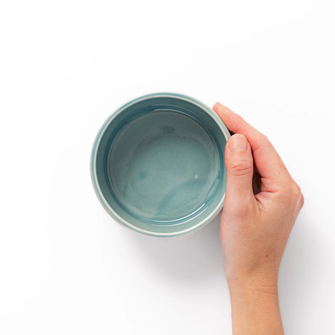 Light blue stackable porcelain bowl with embossed Seigaiha wave pattern, showcasing smooth matte texture and minimalist Japanese design.