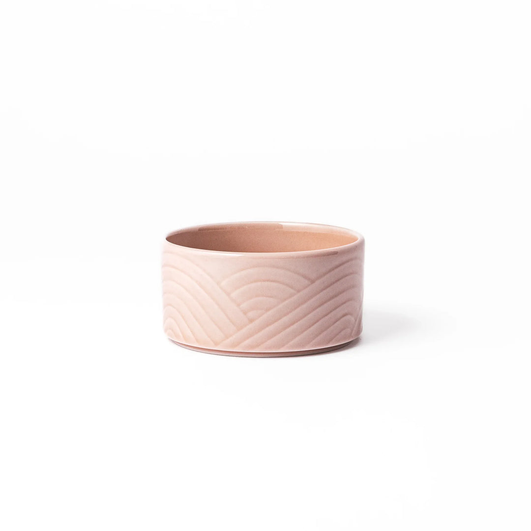 Soft pink stackable porcelain bowl with embossed Seigaiha wave pattern, blending modern simplicity with gentle Japanese warmth.
