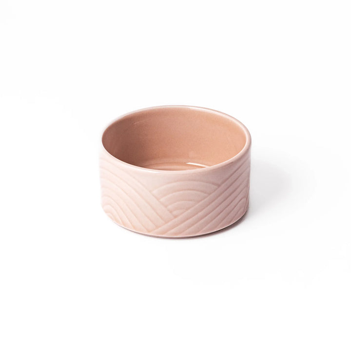 Soft pink stackable porcelain bowl with embossed Seigaiha wave pattern, blending modern simplicity with gentle Japanese warmth.