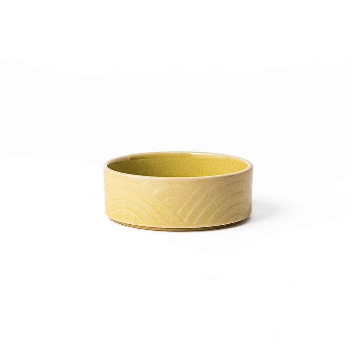Small yellow porcelain bowl with an embossed Seigaiha wave pattern, offering a gentle matte finish and minimalist Japanese design.