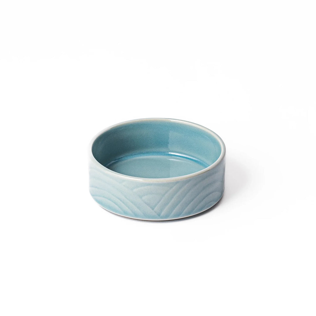 Light blue porcelain bowl embossed with a gentle Seigaiha wave pattern, showcasing a serene and minimalist Japanese design.