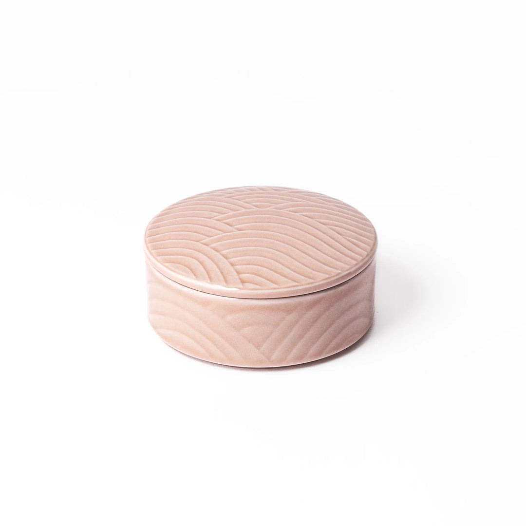 Light pink porcelain bowl with matching lid, featuring embossed Japanese wave pattern and glossy finish on a white background.