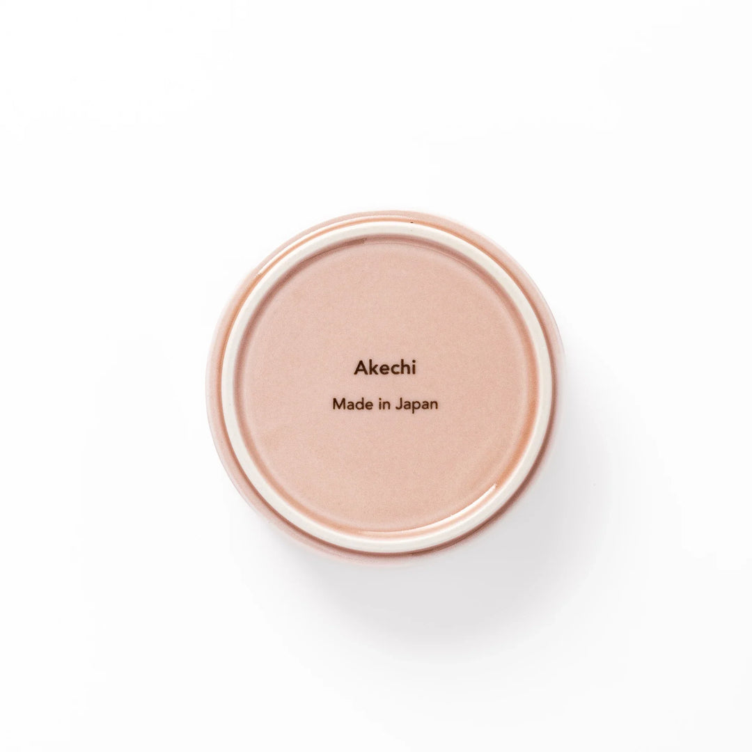 Light pink porcelain bowl with embossed Japanese wave pattern, simple cylindrical shape and glossy finish on a white background.