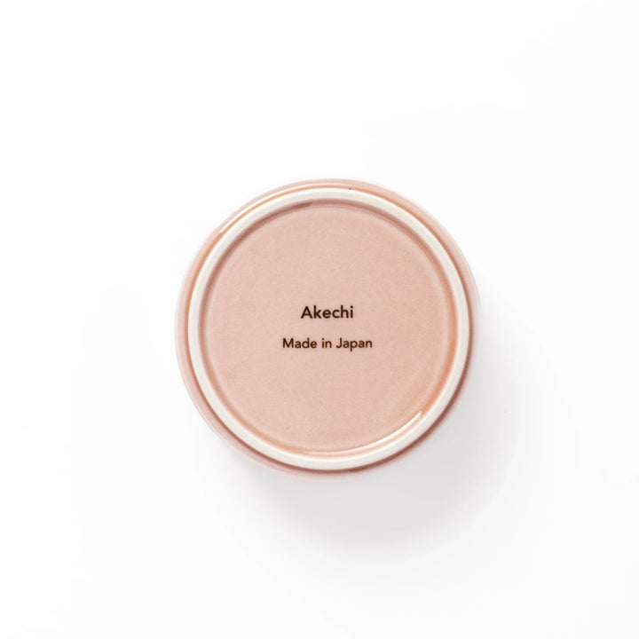 Light pink porcelain bowl with embossed Japanese wave pattern, simple cylindrical shape and glossy finish on a white background.