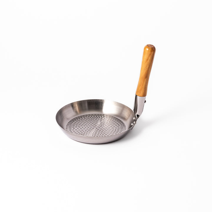Japanese stainless steel donburi pot with a wooden handle and hammered base, designed for evenly heating and serving rice bowls, simmered dishes, and sauces.