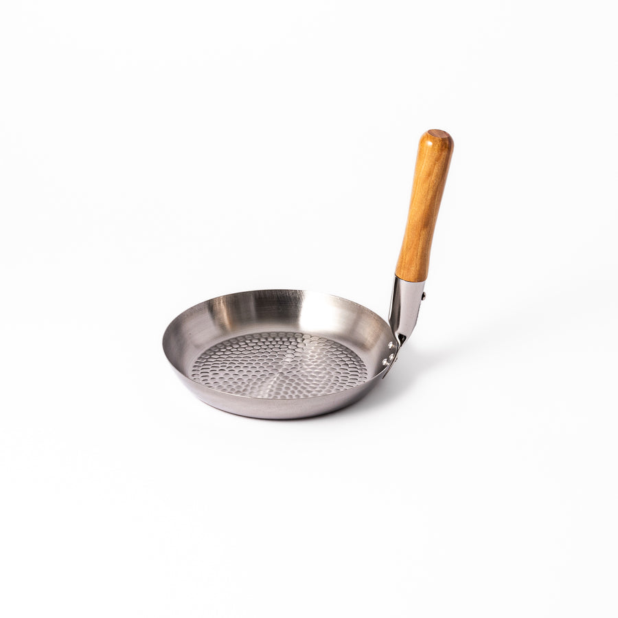 Japanese stainless steel donburi pot with a wooden handle and hammered base, designed for evenly heating and serving rice bowls, simmered dishes, and sauces.