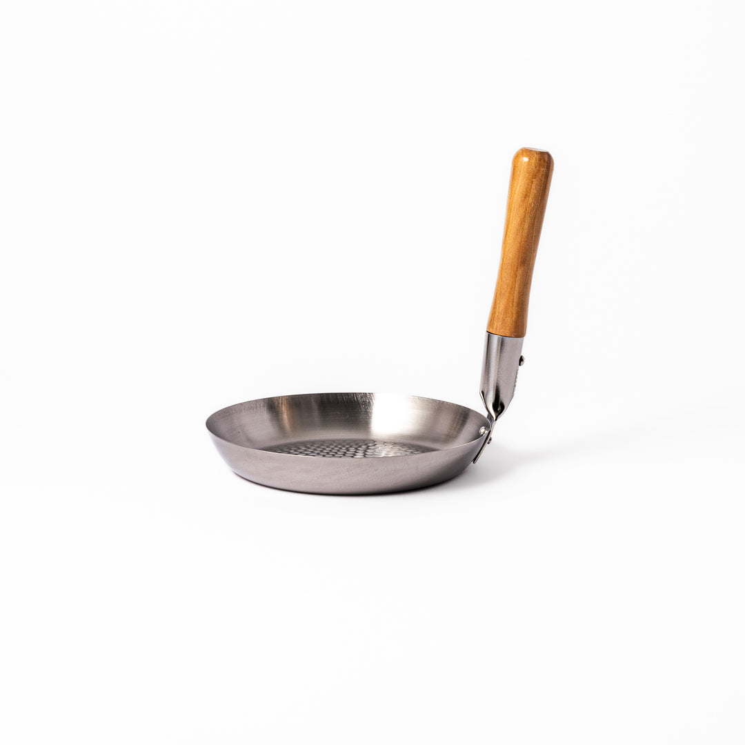 Japanese stainless steel donburi pot with a wooden handle and hammered base, designed for evenly heating and serving rice bowls, simmered dishes, and sauces.