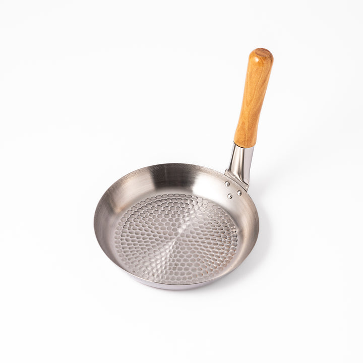 Japanese stainless steel donburi pot with a wooden handle and hammered base, designed for evenly heating and serving rice bowls, simmered dishes, and sauces.