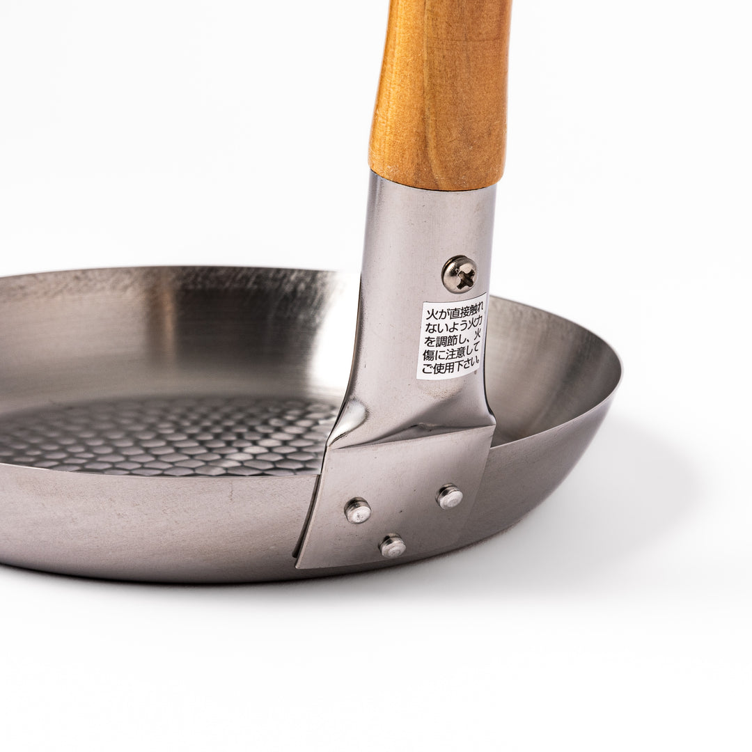 Japanese stainless steel donburi pot with a wooden handle and hammered base, designed for evenly heating and serving rice bowls, simmered dishes, and sauces.