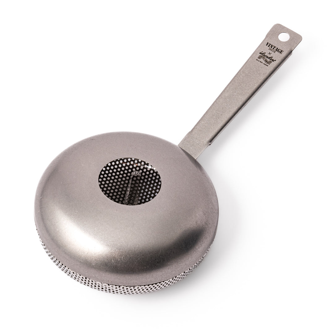Japanese stainless steel hand coffee roaster with perforated drum and long handle, designed for evenly roasting coffee beans over open flame at home.