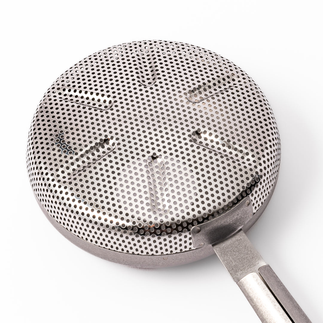 Japanese stainless steel hand coffee roaster with perforated drum and long handle, designed for evenly roasting coffee beans over open flame at home.