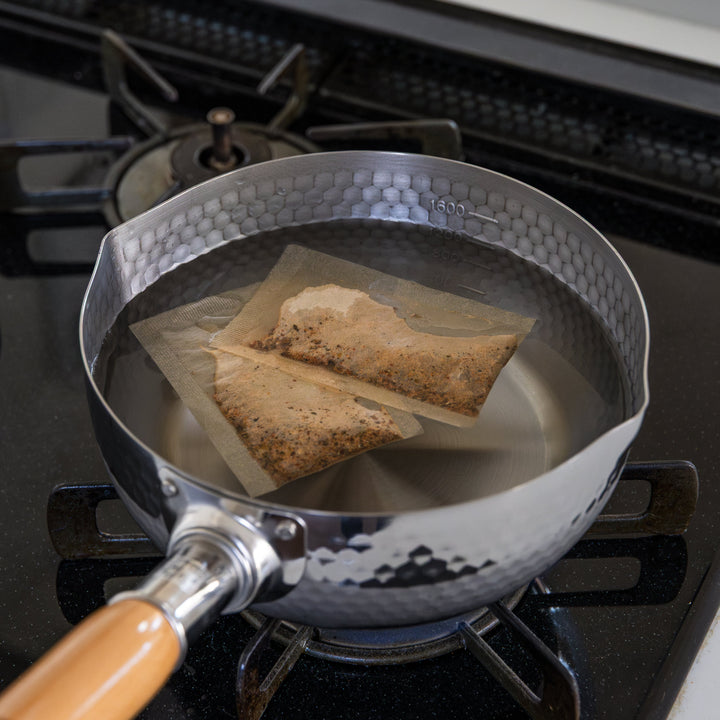 Stainless Steel Yukihira Pot boiling Dashi bags in water on gas stovetop