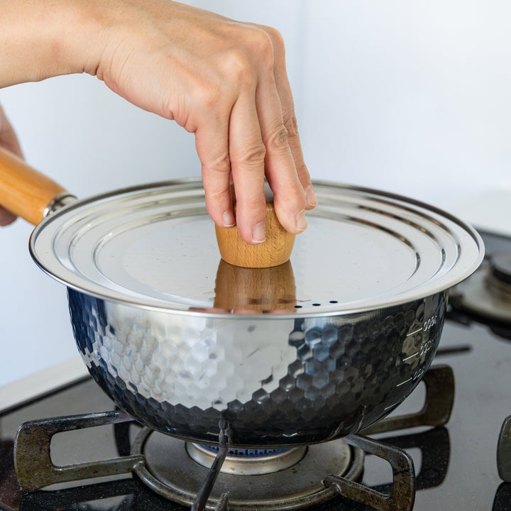 Stainless Steel Yukihira Pot with lid and wooden knob simmering on gas stove