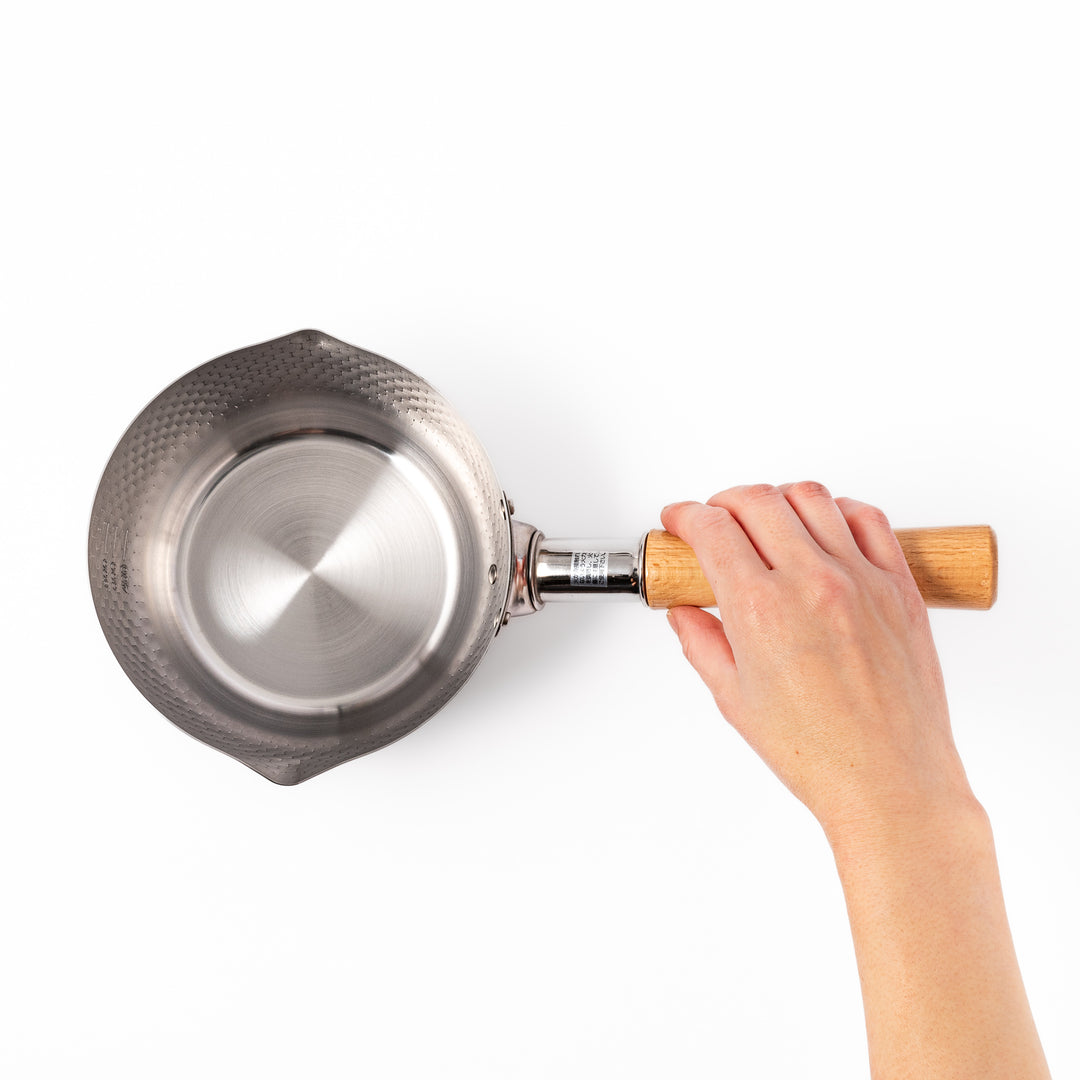 Japanese stainless steel Yukihira pot with a wooden handle and hammered finish, featuring twin pour spouts for easy cooking, simmering, and sauce preparation.