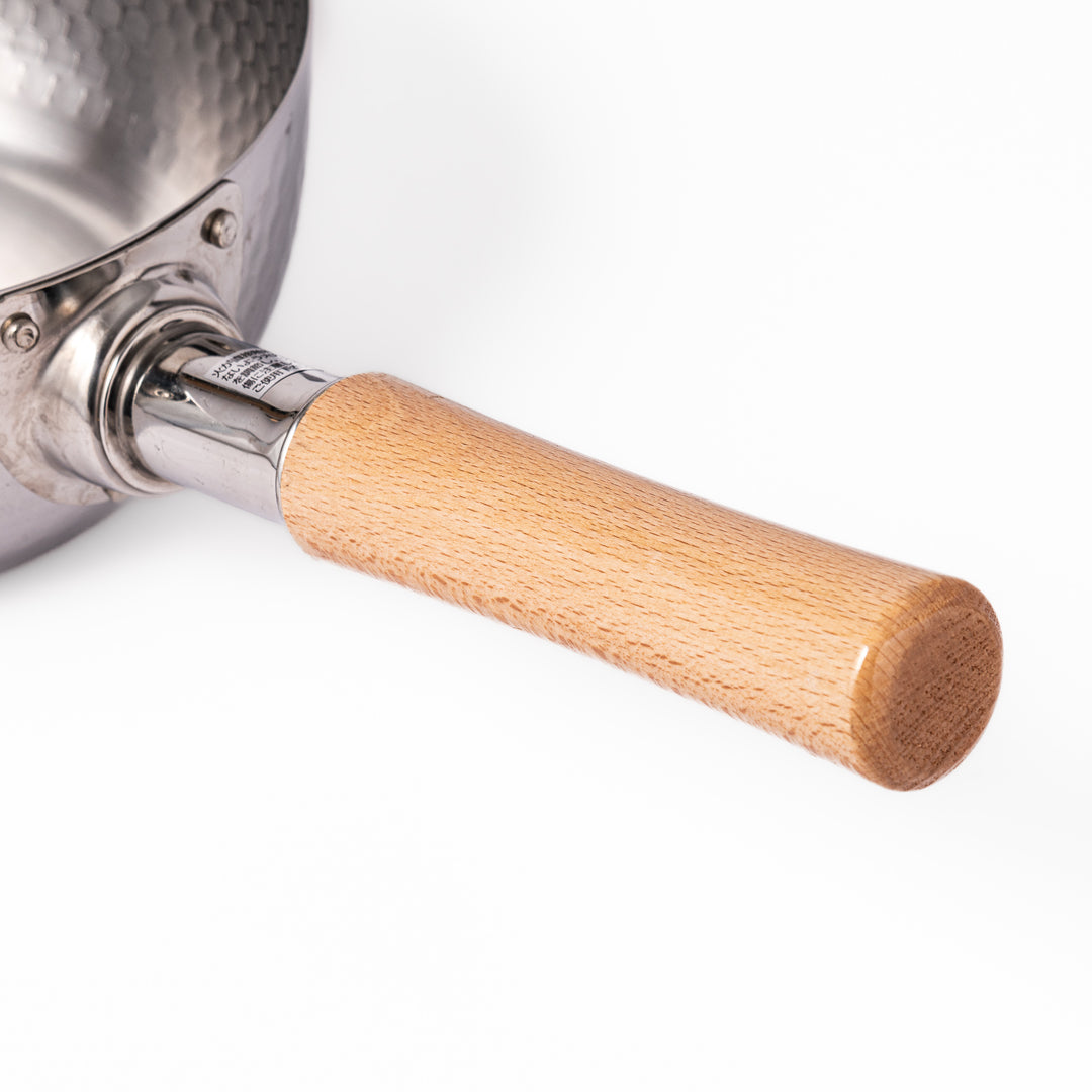 Stainless steel Yukihira pot with a wooden handle featuring a hammered texture and dual pour spouts, ideal for making soups, sauces, and everyday Japanese cooking.