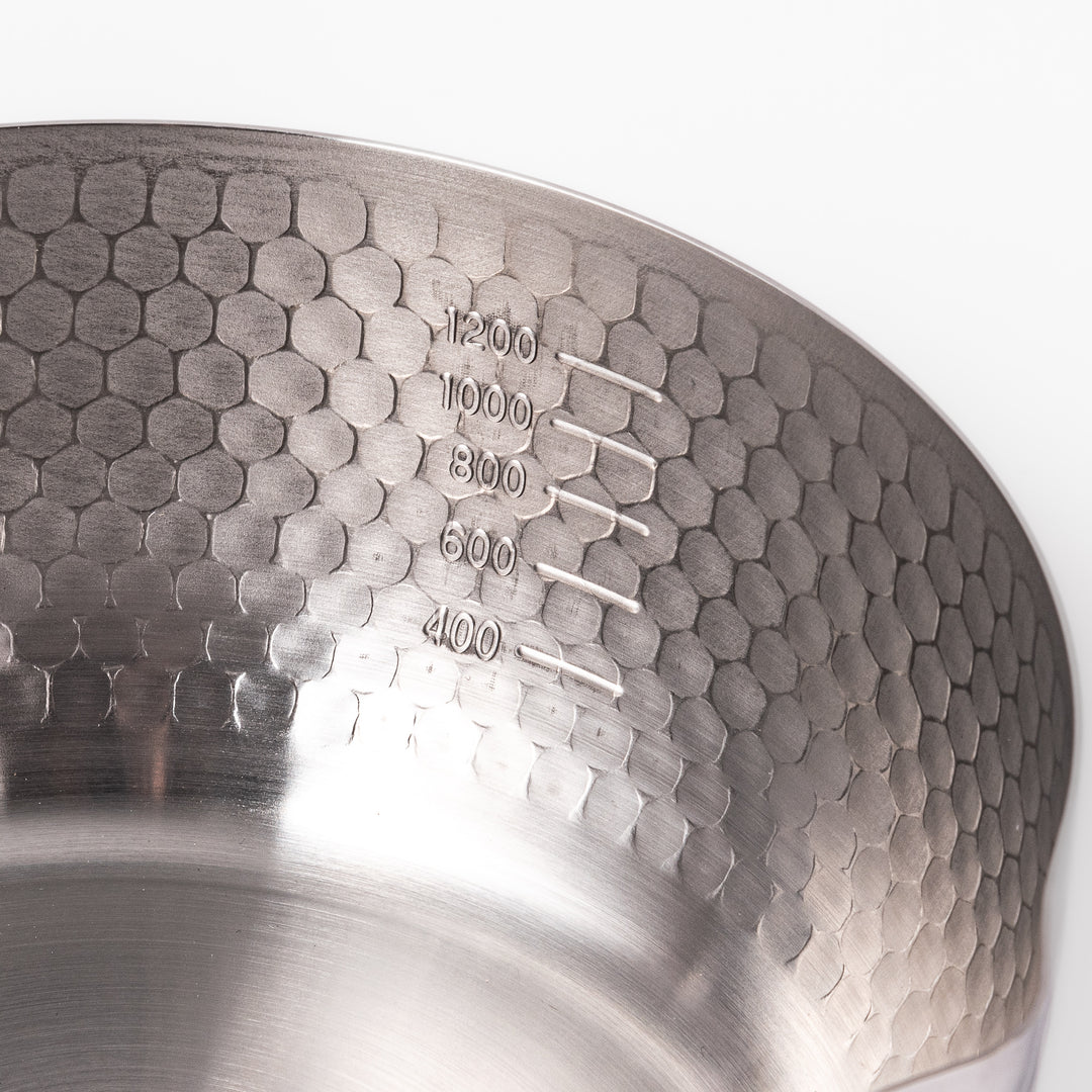 Stainless steel Yukihira pot with a wooden handle featuring a hammered texture and dual pour spouts, ideal for making soups, sauces, and everyday Japanese cooking.