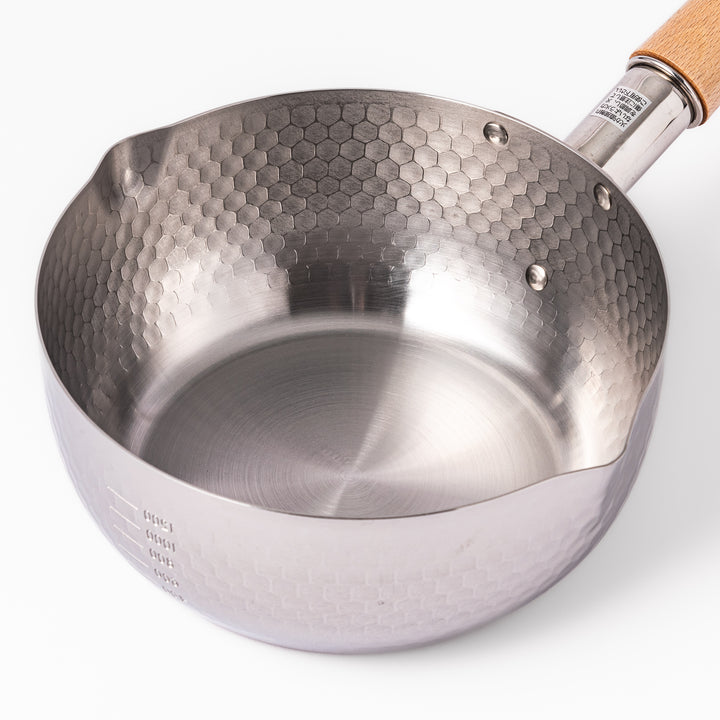 Stainless steel Yukihira pot with a wooden handle featuring a hammered texture and dual pour spouts, ideal for making soups, sauces, and everyday Japanese cooking.