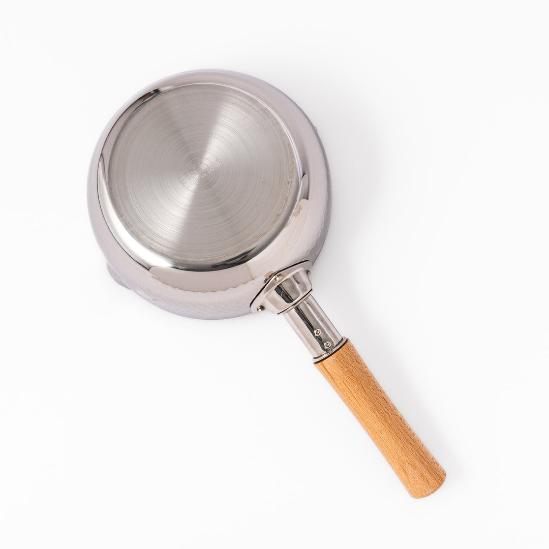 Stainless steel Yukihira pot with a wooden handle featuring a hammered texture and dual pour spouts, ideal for making soups, sauces, and everyday Japanese cooking.