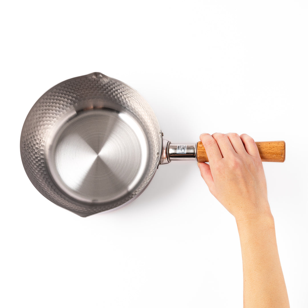 Japanese stainless steel Yukihira pot with a hammered finish and wooden handle, crafted for making soups, sauces, and simmered dishes with even heat distribution.