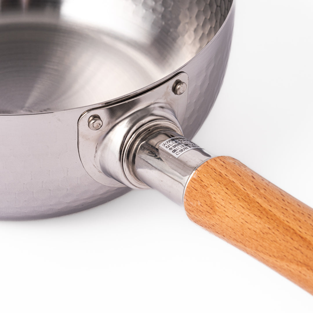 Japanese stainless steel Yukihira pot with a hammered finish and wooden handle, crafted for making soups, sauces, and simmered dishes with even heat distribution.