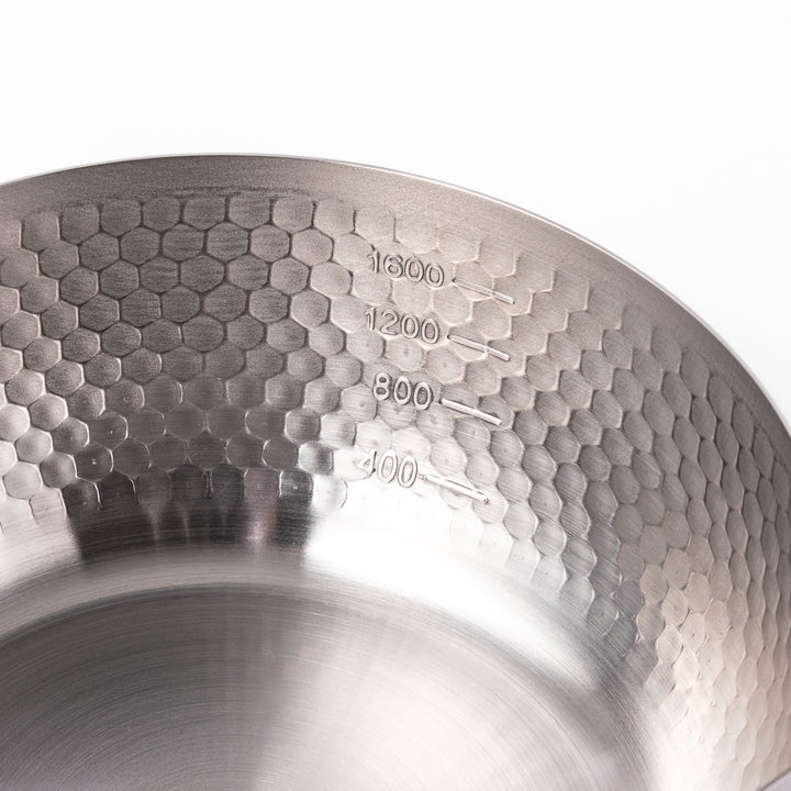 Japanese stainless steel Yukihira pot with a hammered finish and wooden handle, crafted for making soups, sauces, and simmered dishes with even heat distribution.