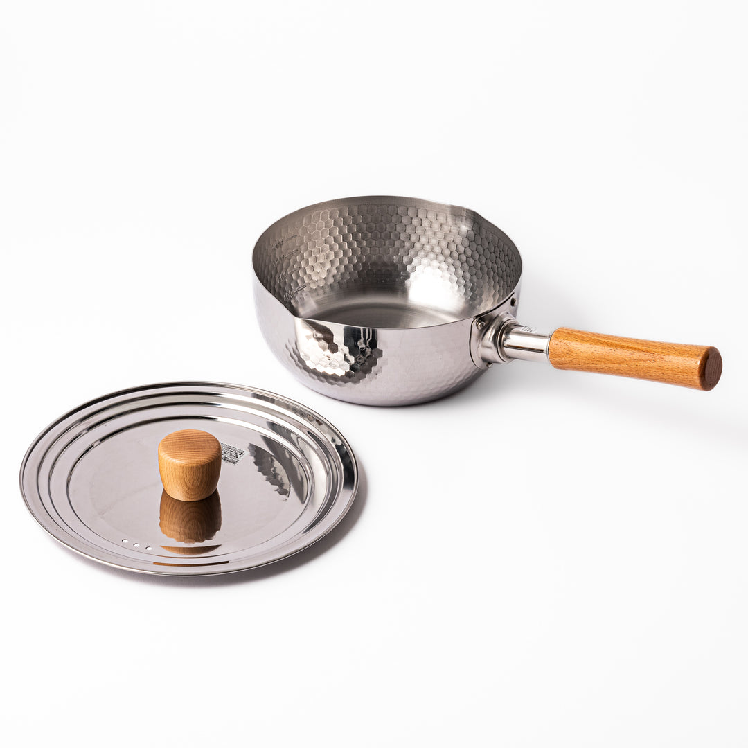 Japanese stainless steel Yukihira pot with a hammered finish, wooden handle, and matching lid, ideal for preparing soups, sauces, and everyday home-cooked meals.