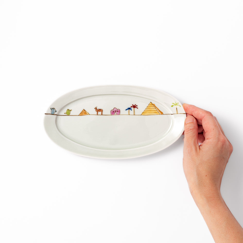 Japanese porcelain oval plate with whimsical Egypt design featuring pyramids, camel, palm trees, and desert-inspired details