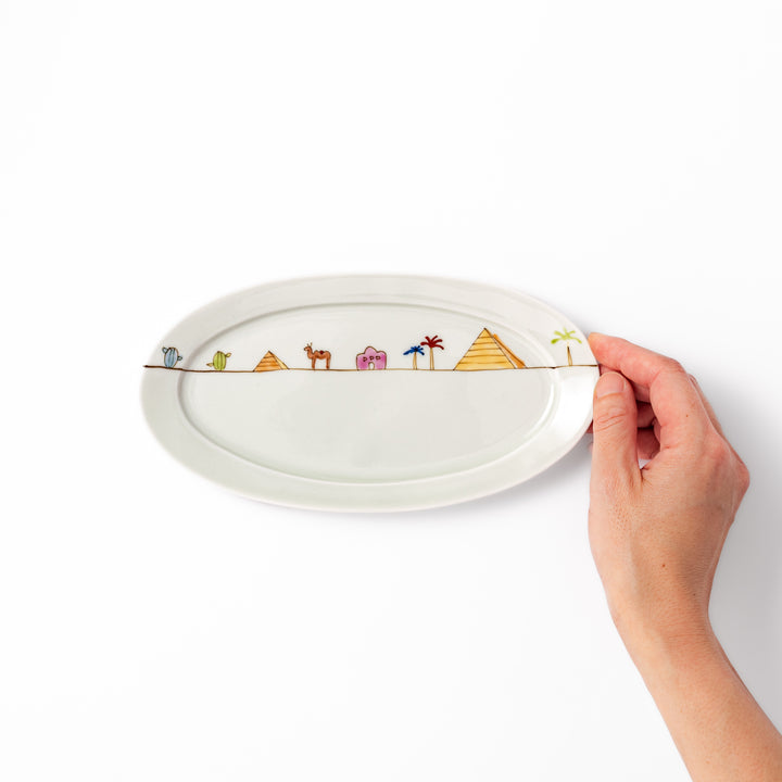 Japanese porcelain oval plate with whimsical Egypt design featuring pyramids, camel, palm trees, and desert-inspired details