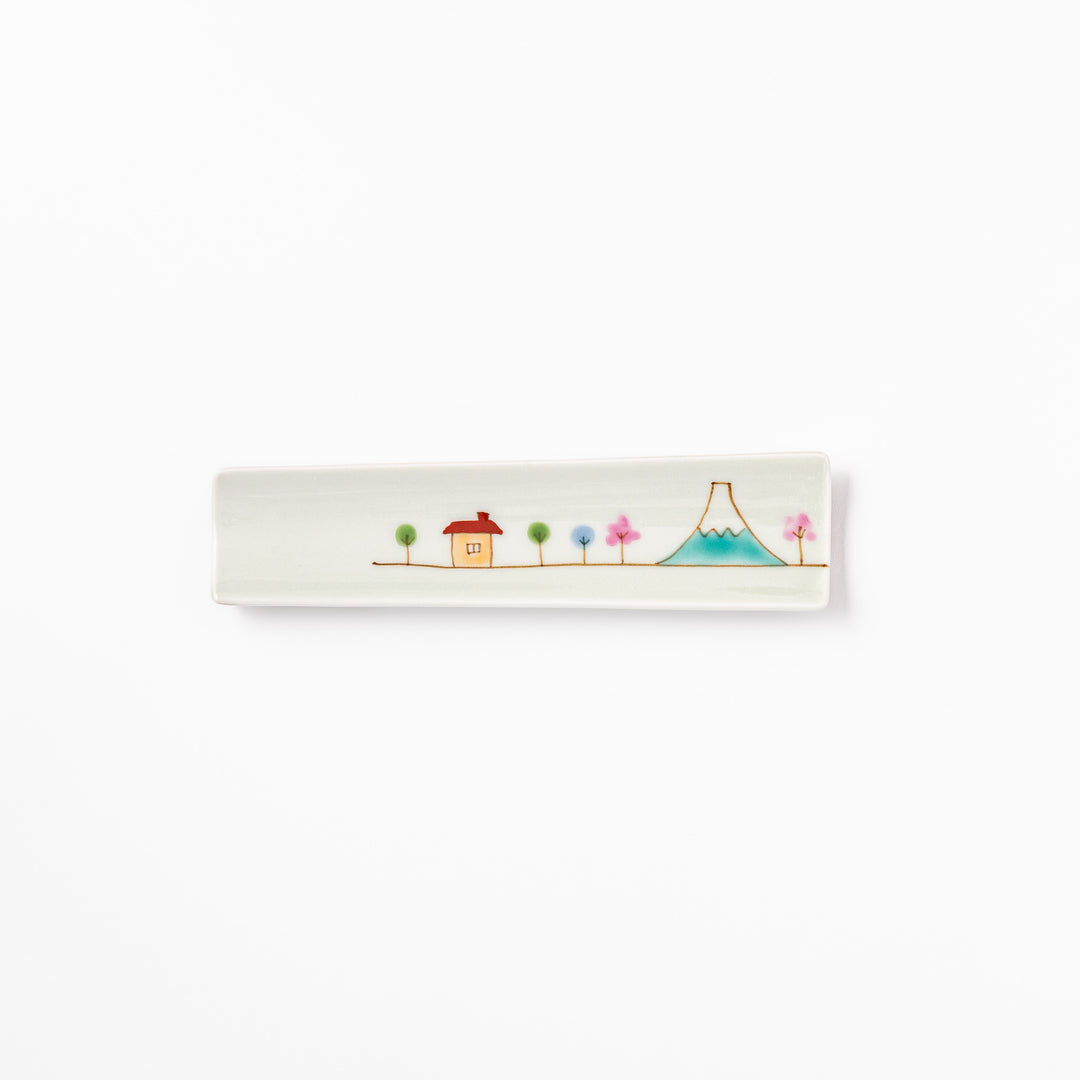 Japanese porcelain chopstick rest with whimsical Japan design featuring Mount Fuji, cherry blossoms, house, and colorful trees