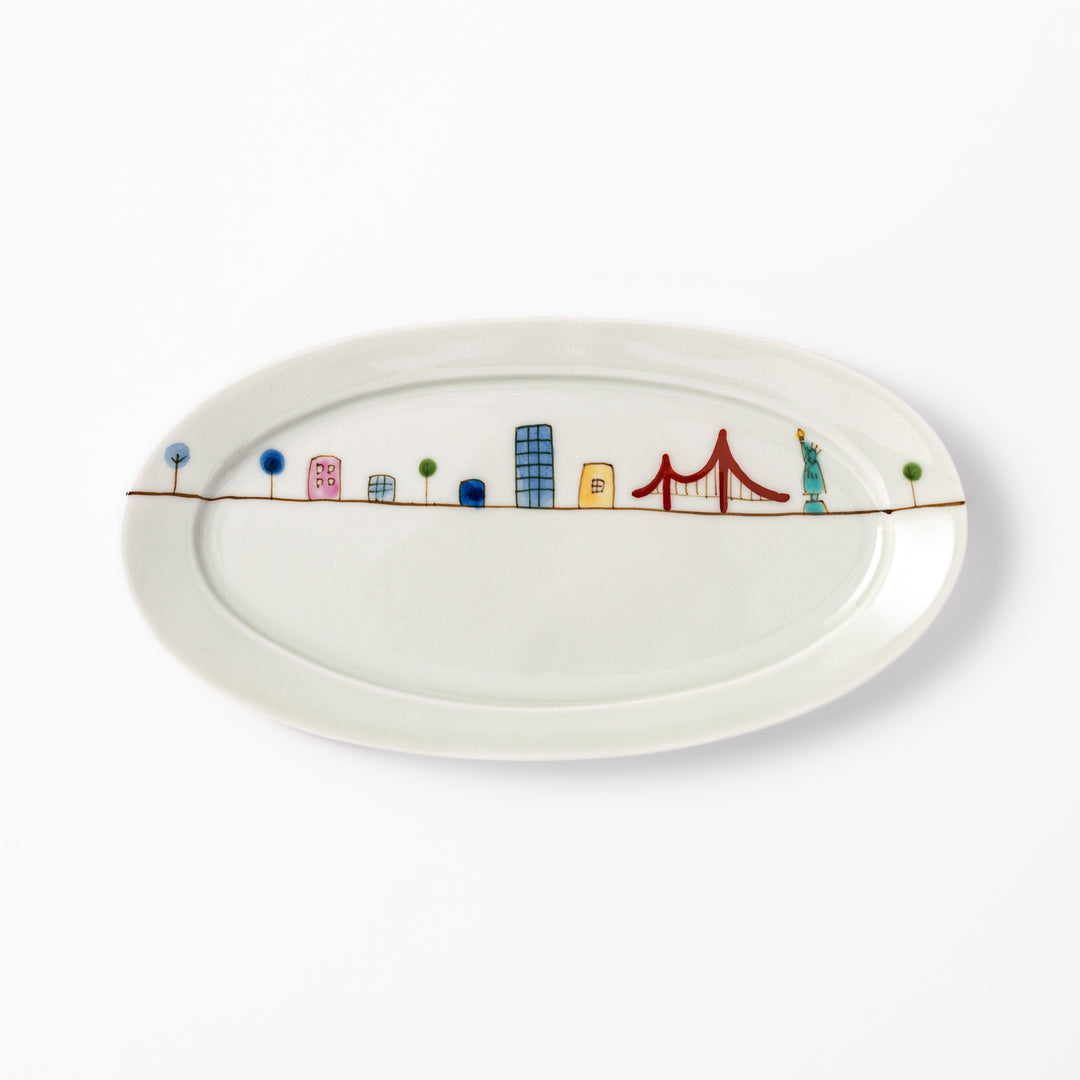 Japanese porcelain oval plate with playful USA cityscape design featuring Statue of Liberty, bridge, and colorful buildings