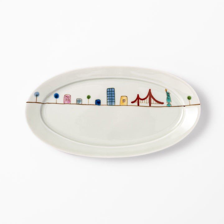 Japanese porcelain oval plate with playful USA cityscape design featuring Statue of Liberty, bridge, and colorful buildings