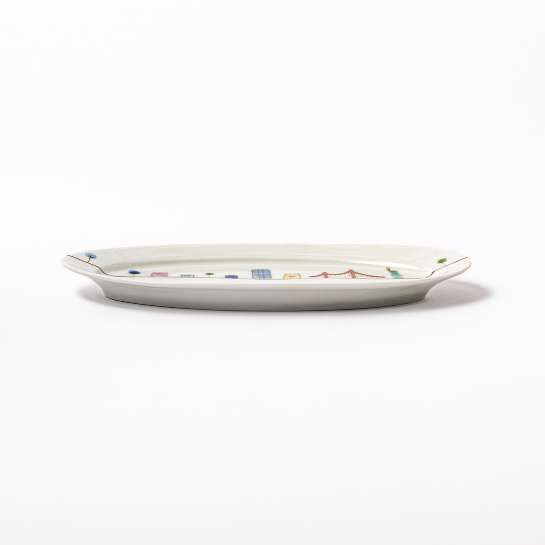 Japanese porcelain oval plate with playful USA cityscape design featuring Statue of Liberty, bridge, and colorful buildings