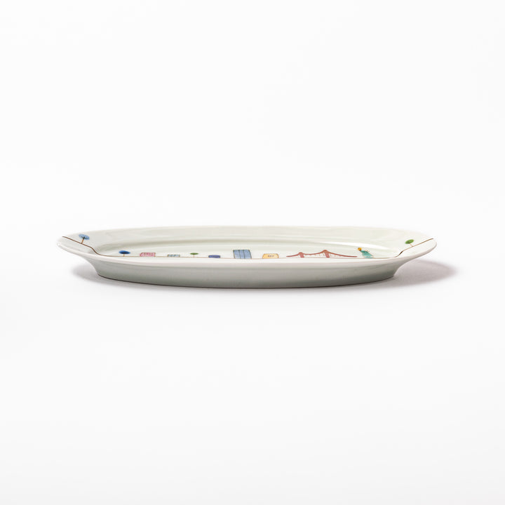 Japanese porcelain oval plate with playful USA cityscape design featuring Statue of Liberty, bridge, and colorful buildings
