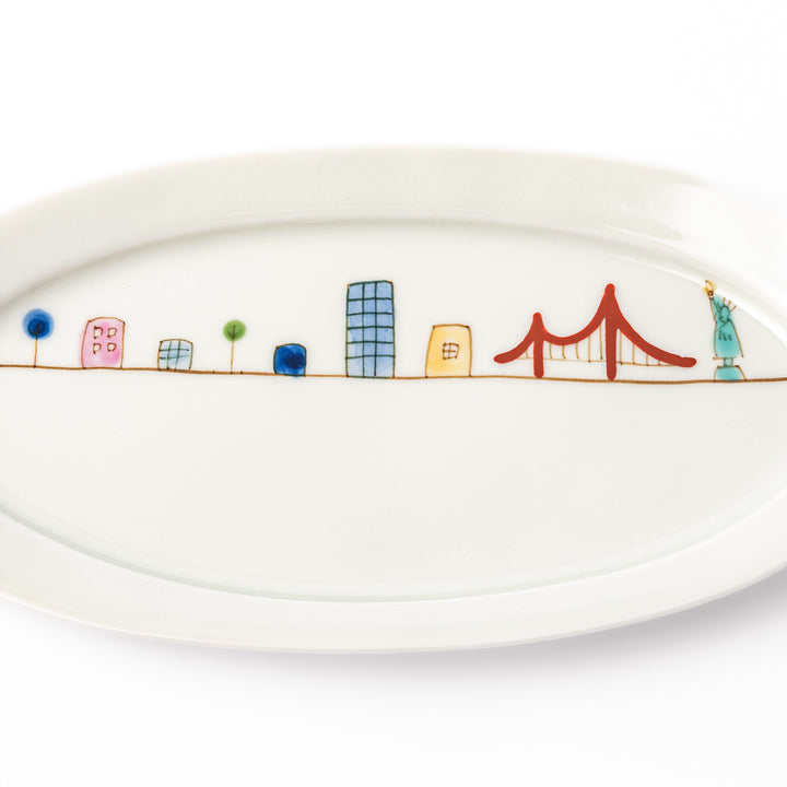 Japanese porcelain oval plate with playful USA cityscape design featuring Statue of Liberty, bridge, and colorful buildings