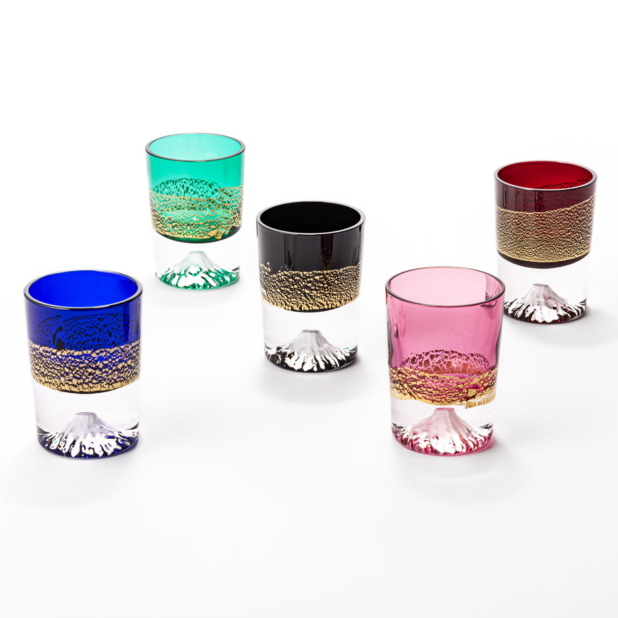 Five colorful sake glasses, each featuring gold-leaf landscapes and a sculpted Mount Fuji at the base, blending tradition with vibrant design.
