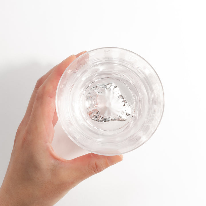 Clear glass with a subtle sakura pattern on the surface, featuring a distinctive mountain-shaped base, viewed from the side.