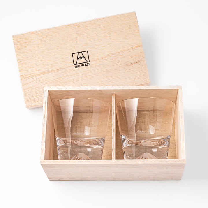 Two glasses placed inside a wooden box with the Edo Glass logo visible on the top of the box. The glasses feature a detailed design resembling Mount Fuji at the base.