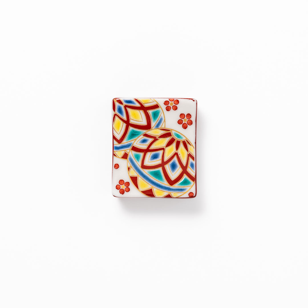 Rectangular Japanese ceramic chopstick rest adorned with colorful temari ball patterns and red floral accents, bringing vibrant charm to any dining table.