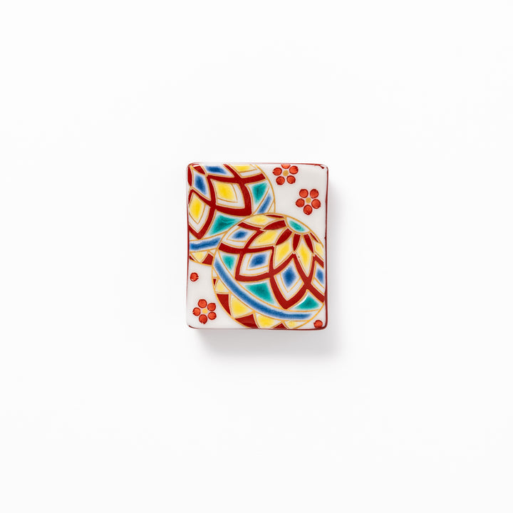 Rectangular Japanese ceramic chopstick rest adorned with colorful temari ball patterns and red floral accents, bringing vibrant charm to any dining table.