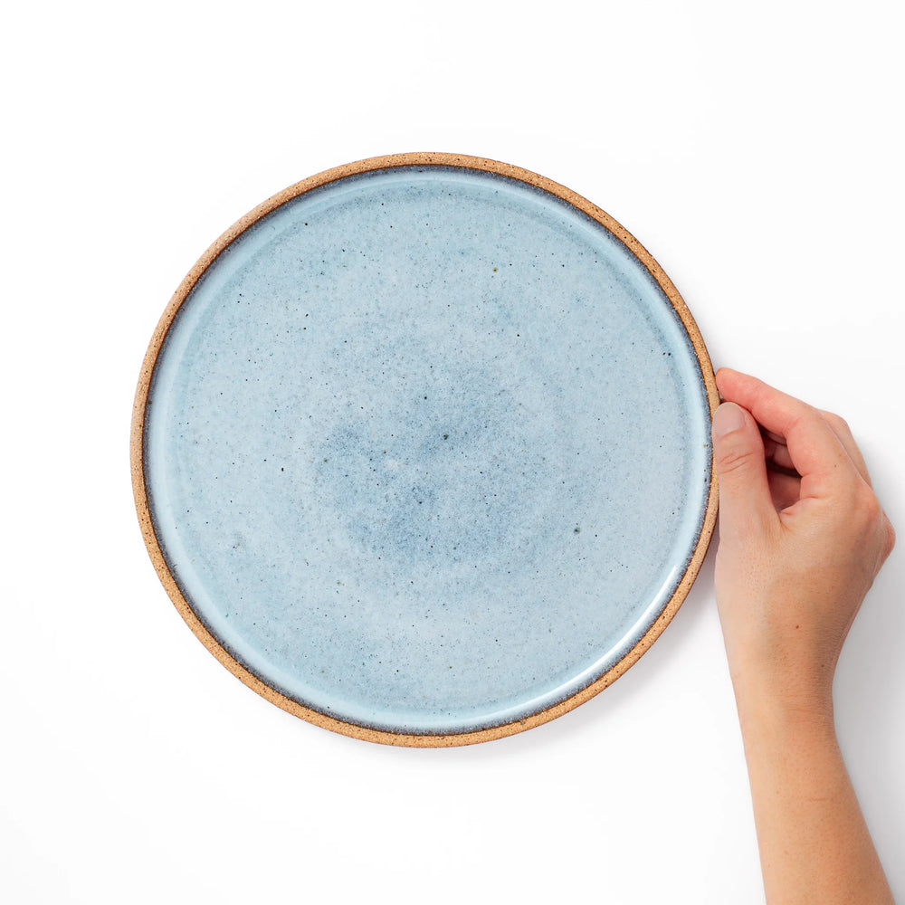 Terracotta blue ceramic dinner plate with rustic brown rim, handcrafted in Japan for serving main dishes, pasta, or everyday meals.