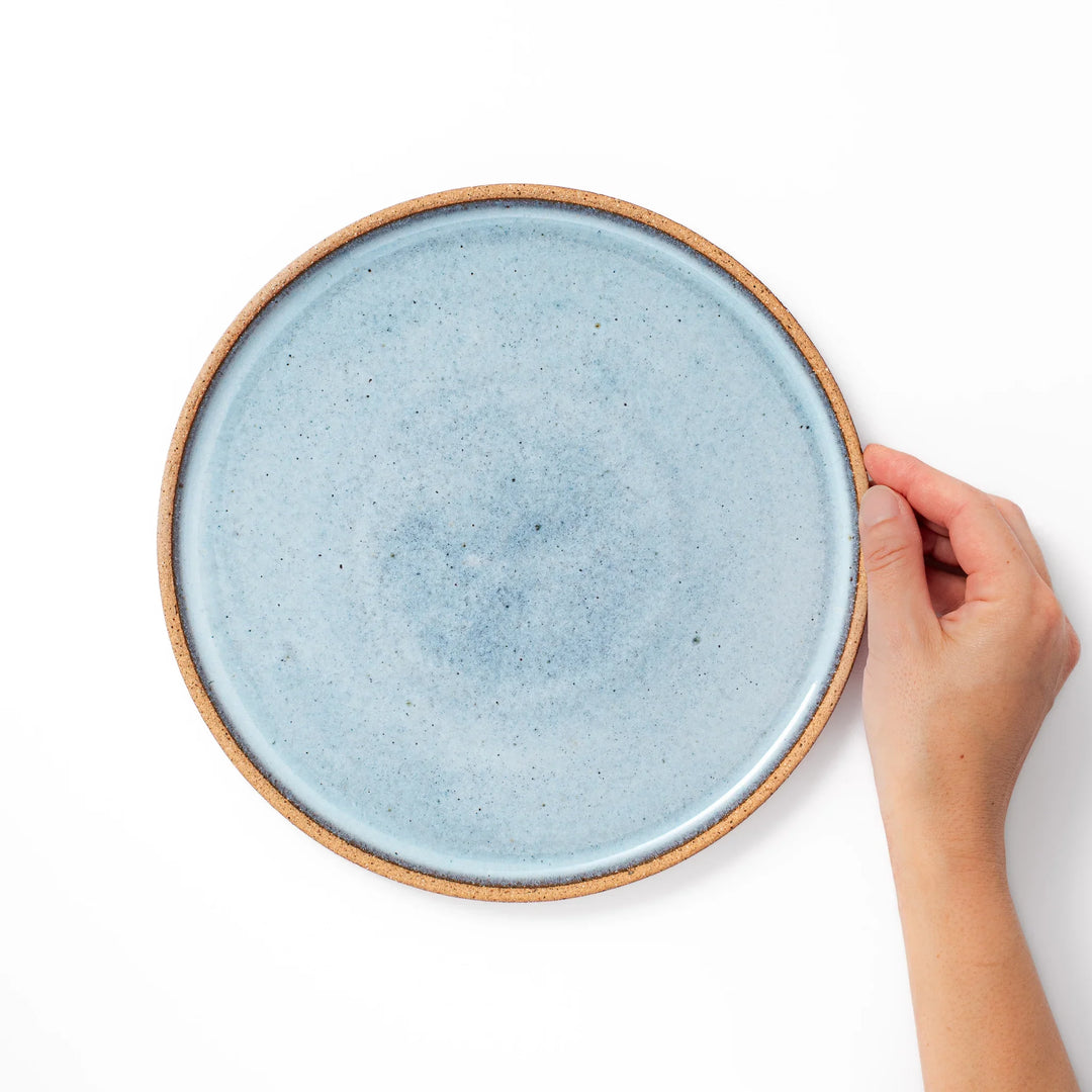 Terracotta blue ceramic dinner plate with rustic brown rim, handcrafted in Japan for serving main dishes, pasta, or everyday meals.
