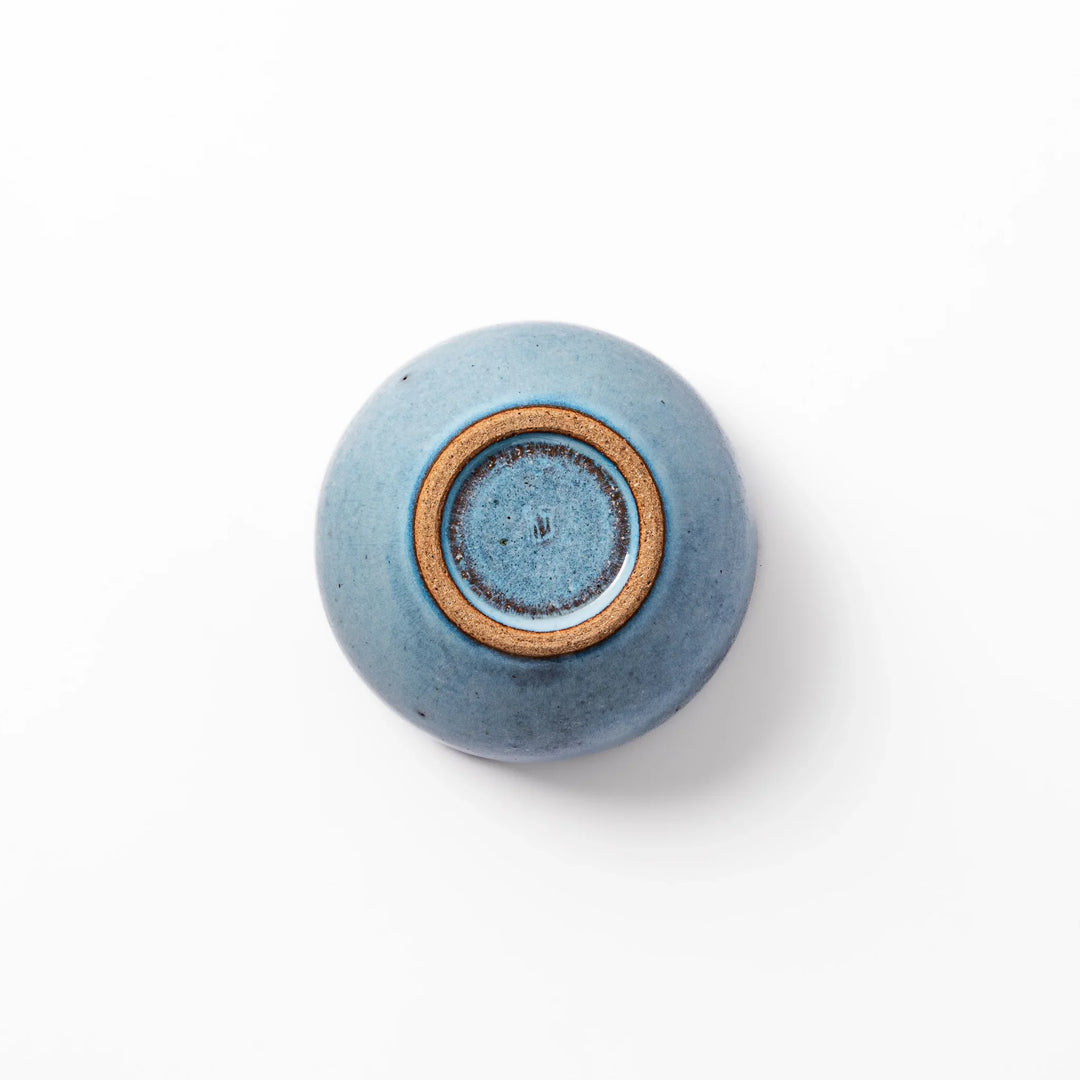 Terracotta blue ceramic tea cup with rustic brown rim, handcrafted in Japan for serving green tea, coffee, or everyday hot drinks.