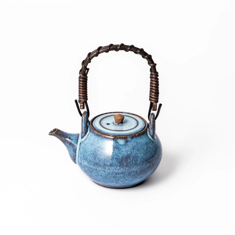 Terracotta blue ceramic teapot with rustic brown rim and woven metal handle, handcrafted in Japan for serving green tea or everyday brewing.