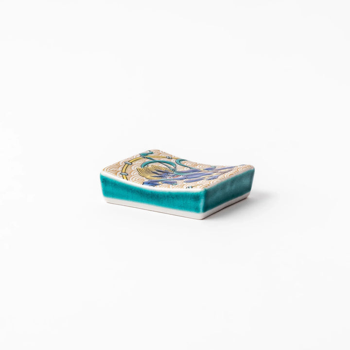 Japanese porcelain chopstick rest featuring the Thunder God design with blue figure and gold wave pattern background.
