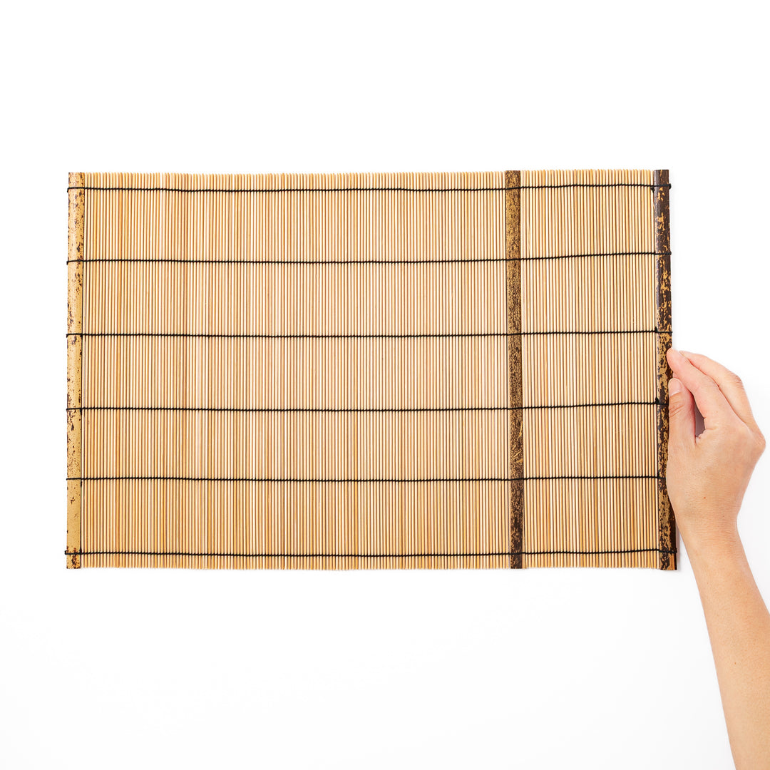 Japanese woven bamboo placemat in natural white tones with black thread accent for elegant dining table setup