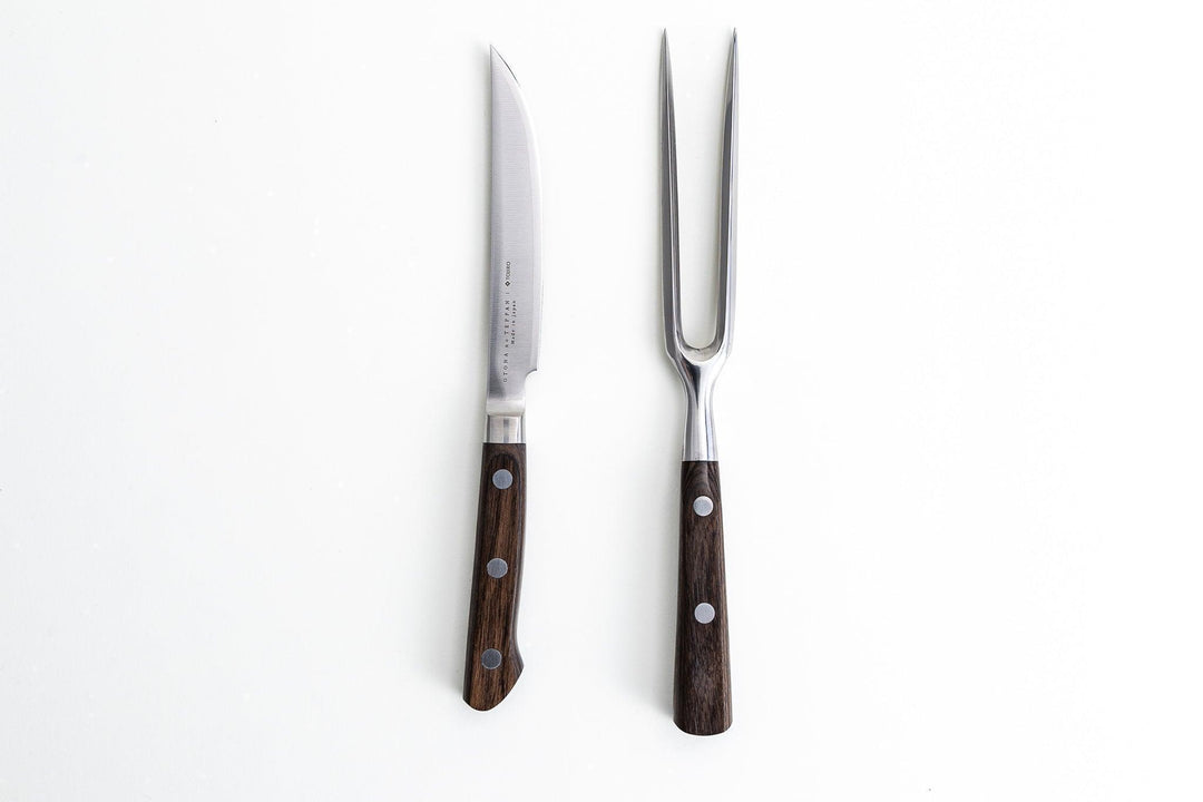 Japanese carving knife and meat fork with dark wood handles on a white background