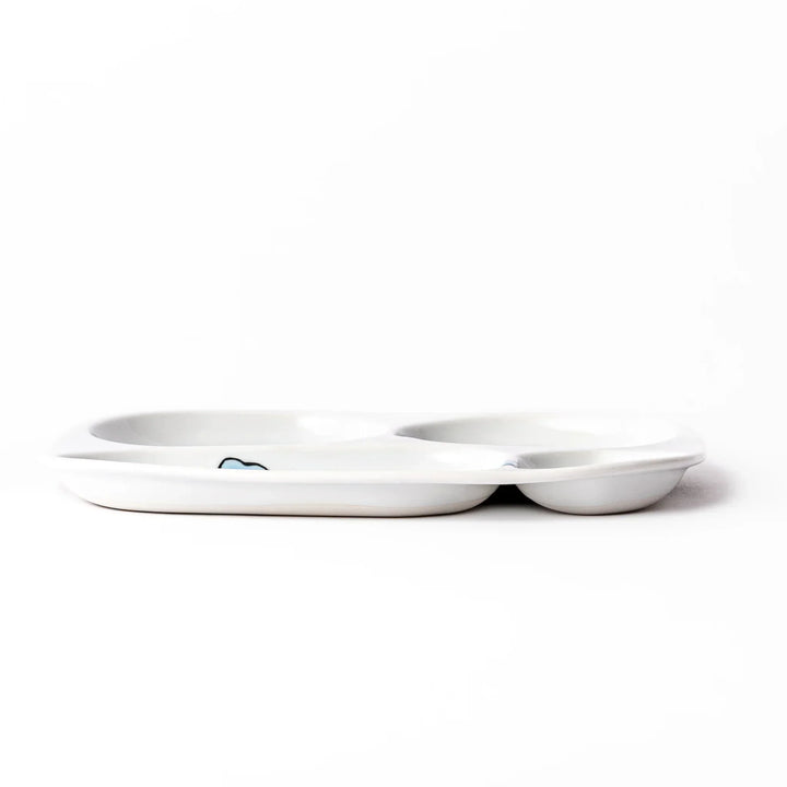 White ceramic kids divided plate with blue triceratops, yellow pterodactyl, red erupting volcano and blue cloud accents