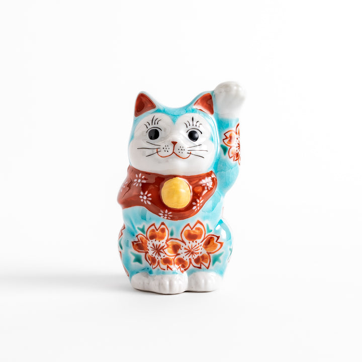 Vibrant Turkish blue Maneki Neko figurine adorned with floral patterns in orange and white, featuring a golden bell and a raised paw, symbolizing good fortune and prosperity.