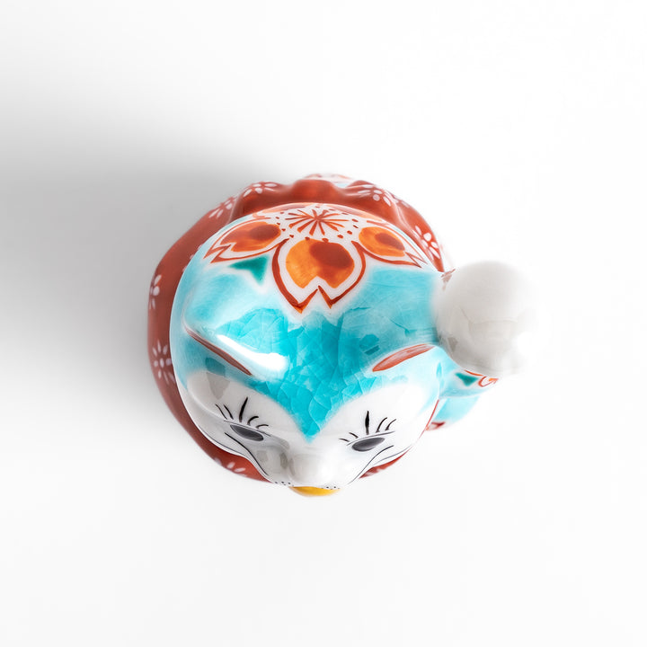 Vibrant Turkish blue Maneki Neko figurine adorned with floral patterns in orange and white, featuring a golden bell and a raised paw, symbolizing good fortune and prosperity.