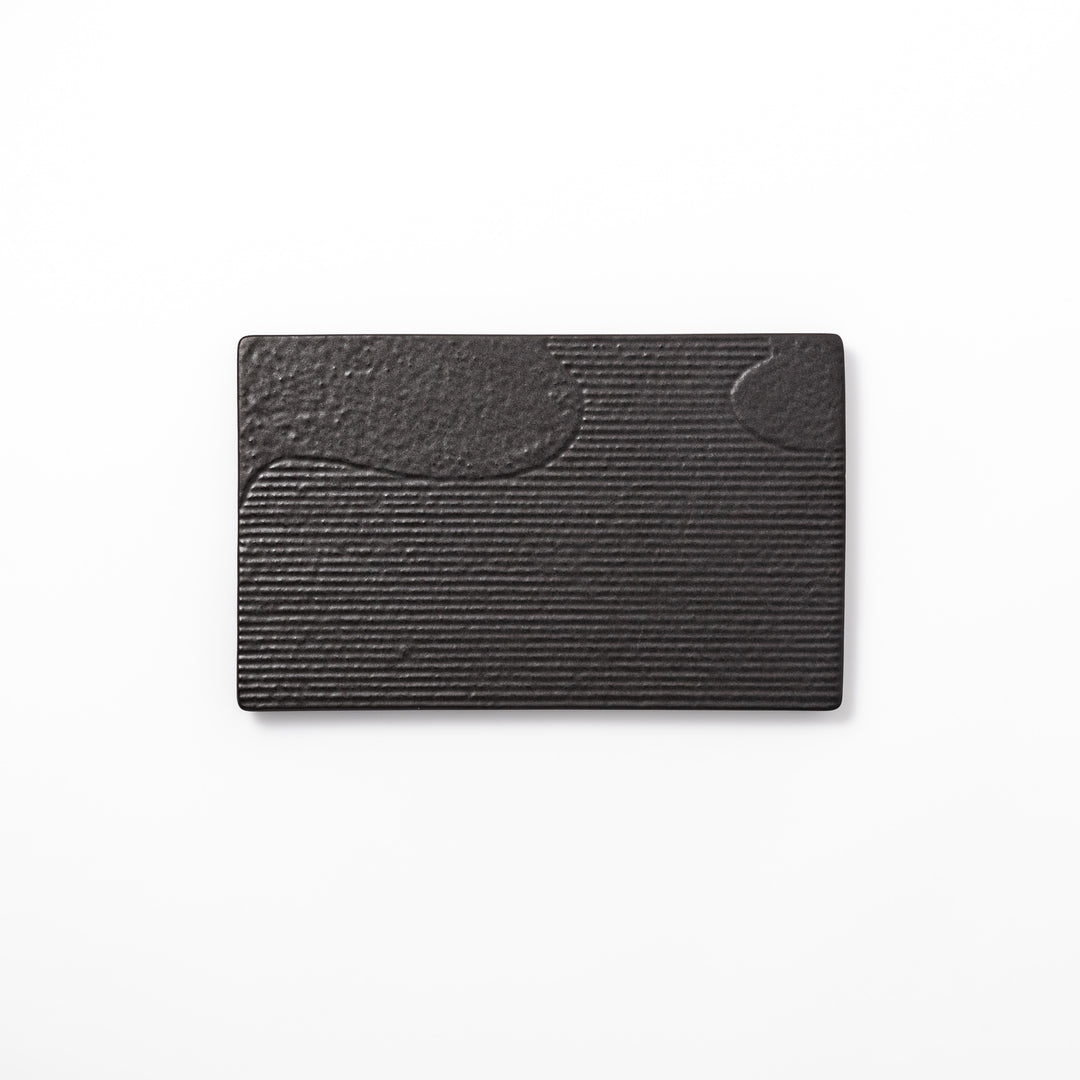 Textured black ceramic dinner plate with ridged woodgrain and matte-gloss accents, ideal for refined Japanese dining and modern presentation.
